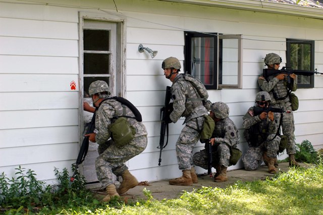 Soldiers from the 2nd Squadron, 107th Cavalry Regiment, 2nd Brigade Combat Team of the 28th Infantry Division enter a house at Muscatatuck Urban Training Center while conducting military operations in urban terrain training during their annual two-week training. U.S. Army photo (Released)